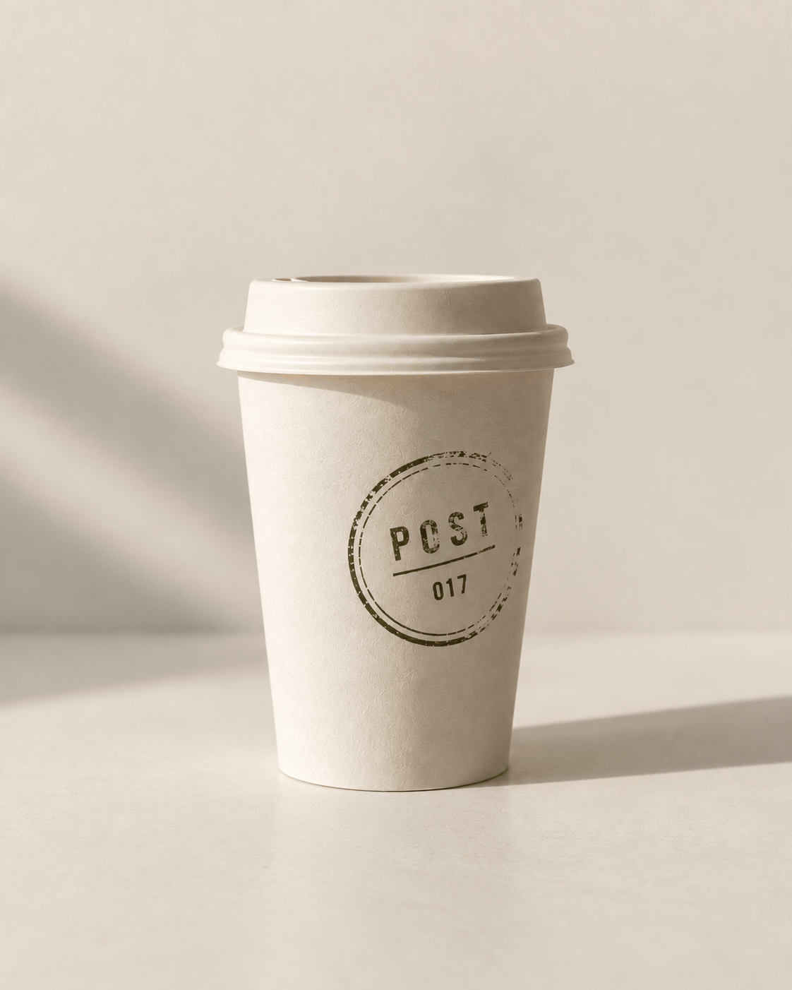 A plain cream Post takeaway cup marked with its outlet postmark.