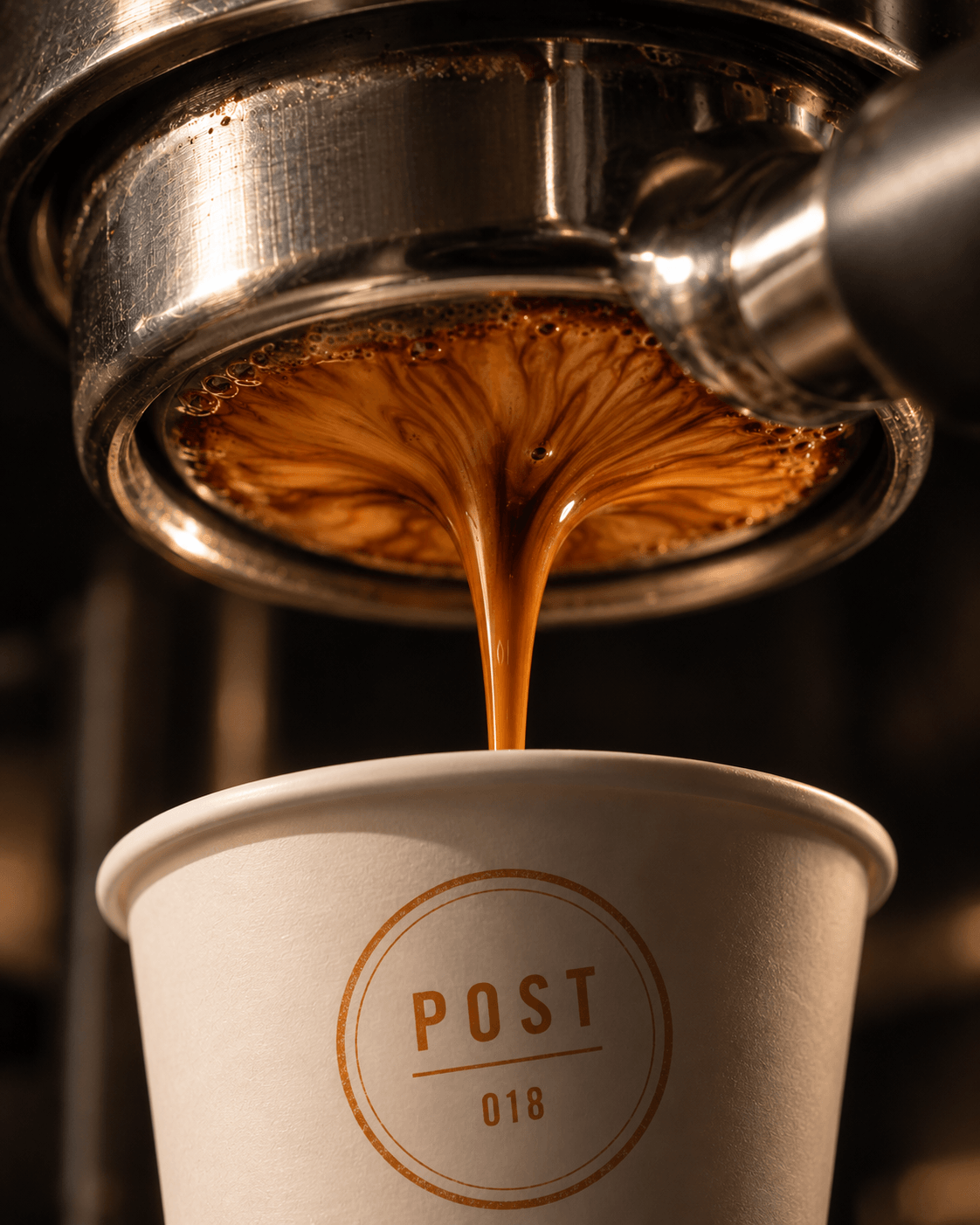 Espresso extracting from a bottomless portafilter into a Post cup.